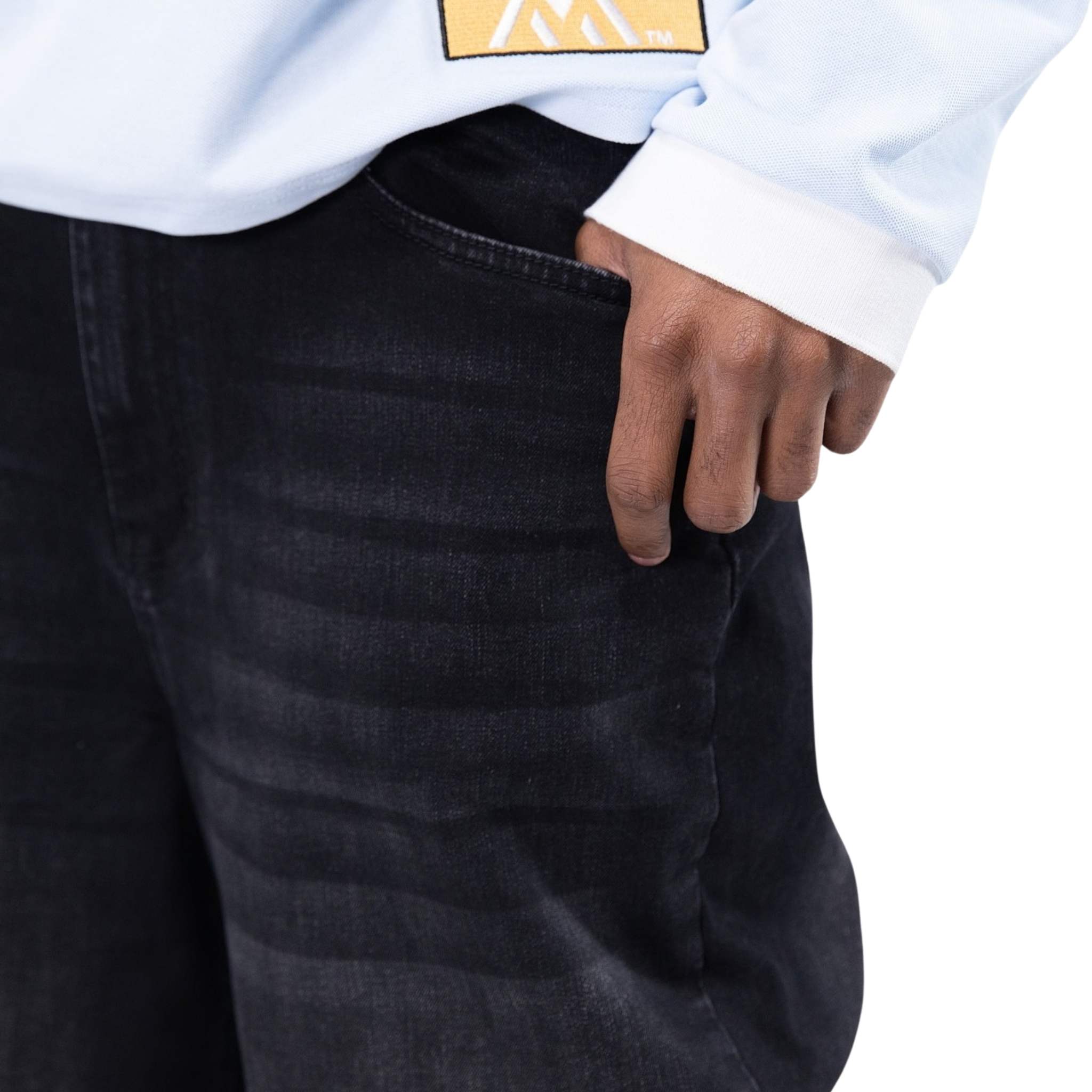 Person wearing black pants with a white shirt and yellow logo on a white background