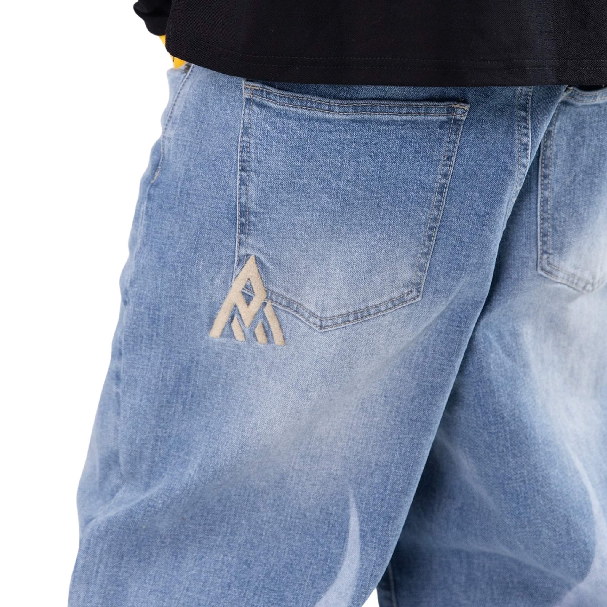 Close-up of blue jeans with a logo on the pocket against a white background