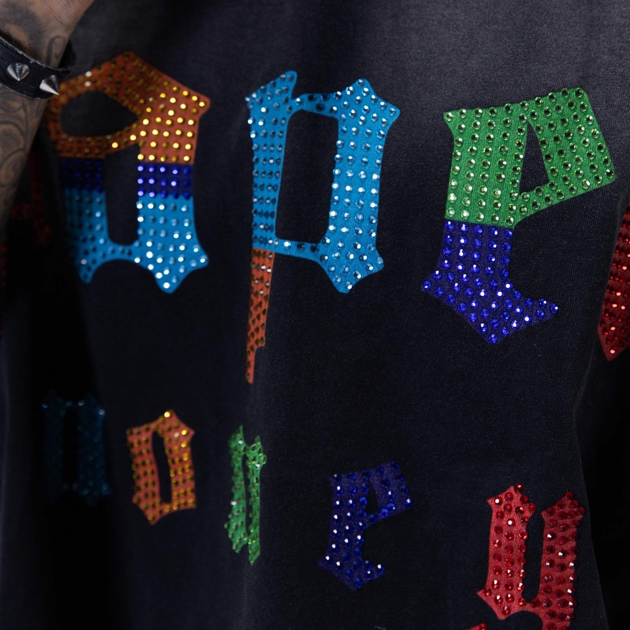 Multi-color studded lettering detail on black t-shirt