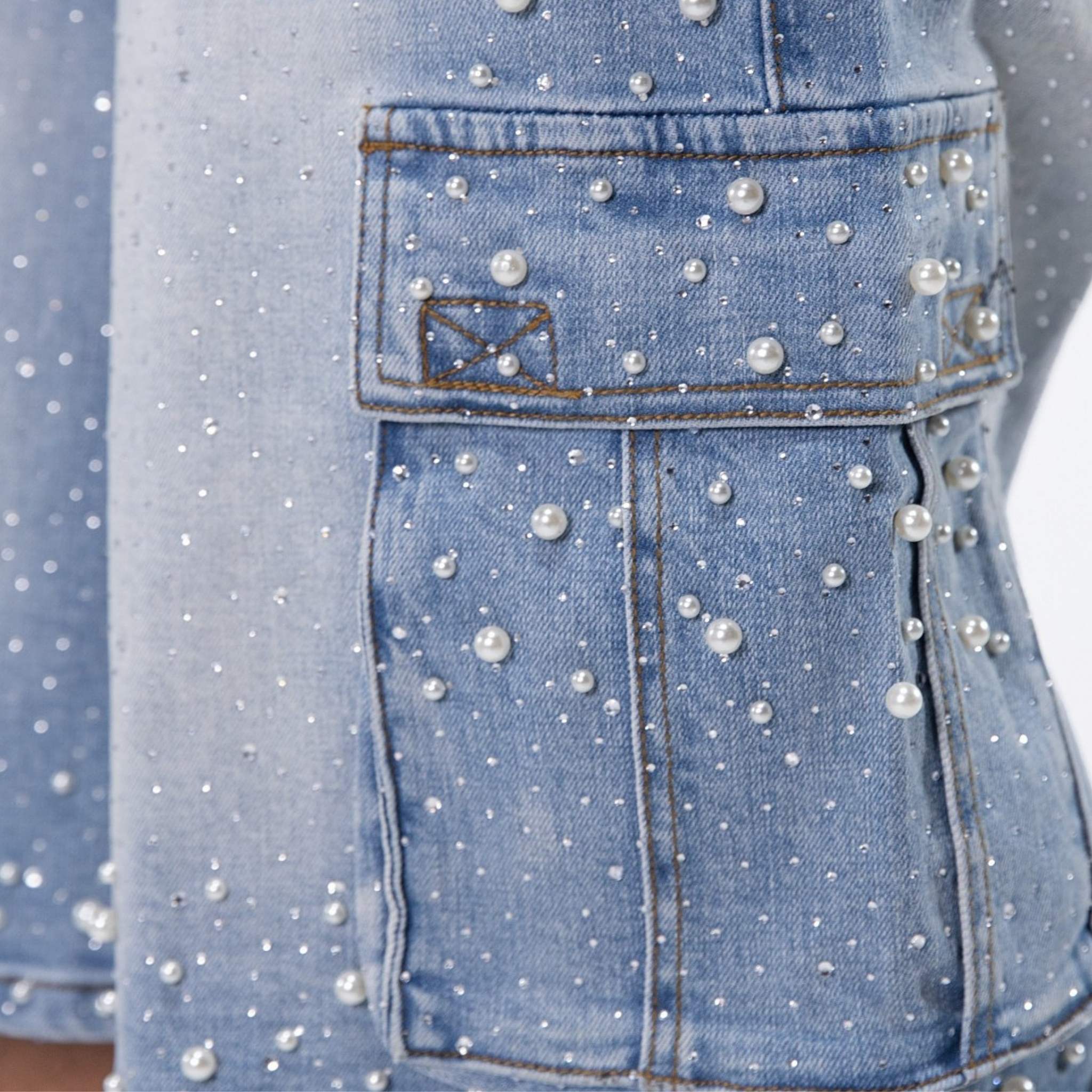 Close-up of pearl and stud embellishments on denim